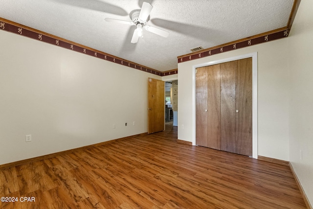 unfurnished bedroom with hardwood / wood-style floors, a closet, ceiling fan, and a textured ceiling