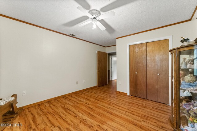 unfurnished bedroom with a closet, light hardwood / wood-style flooring, ceiling fan, and a textured ceiling