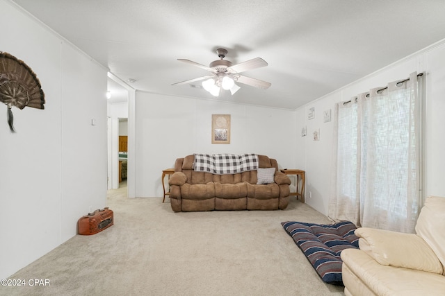 living room with ornamental molding, ceiling fan, and carpet floors