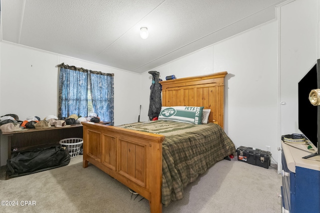 bedroom featuring light colored carpet and a textured ceiling