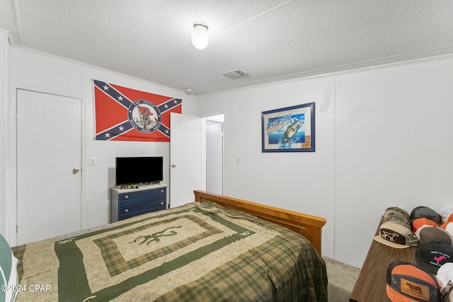 bedroom featuring a textured ceiling and carpet floors