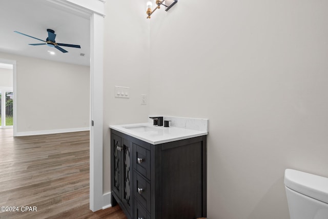 bathroom with vanity, hardwood / wood-style flooring, toilet, and ceiling fan