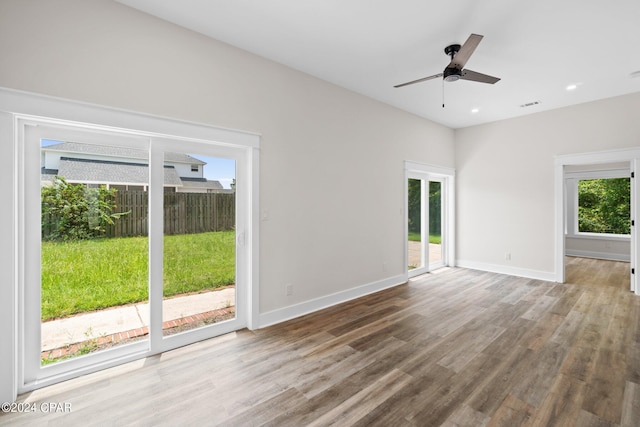 spare room with plenty of natural light, ceiling fan, and hardwood / wood-style flooring