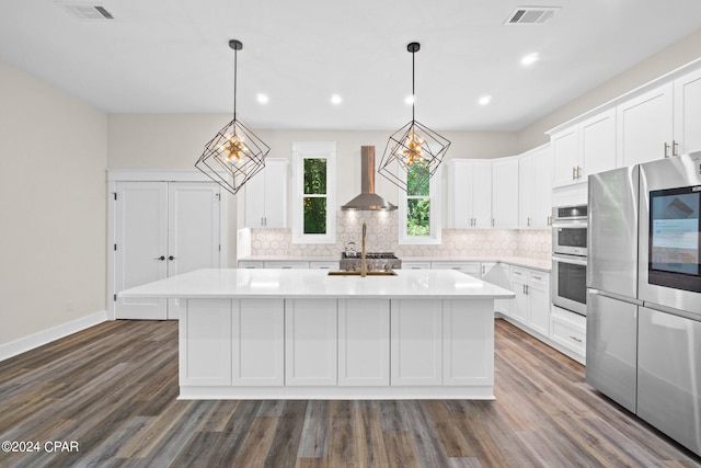 kitchen featuring a center island, dark wood-type flooring, stainless steel double oven, and wall chimney exhaust hood