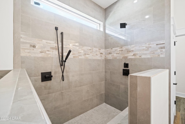 bathroom with tiled shower and hardwood / wood-style floors