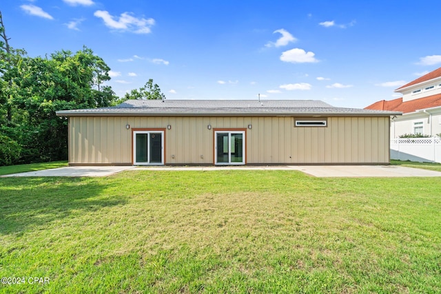 rear view of property featuring a yard and a patio area