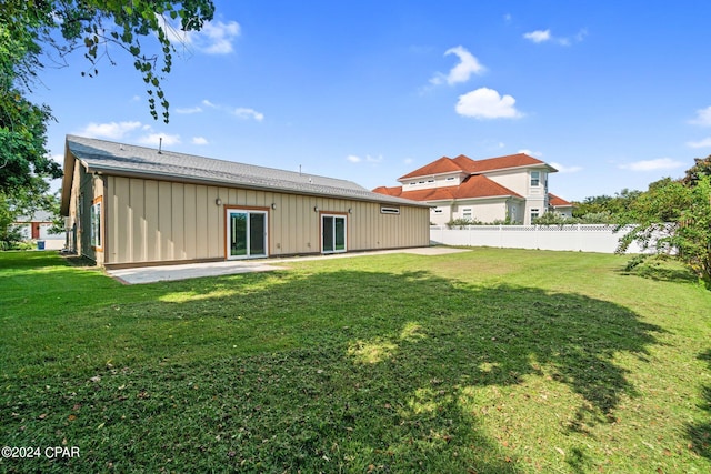 rear view of property featuring a patio and a lawn