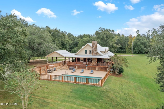 rear view of house featuring a deck and a yard