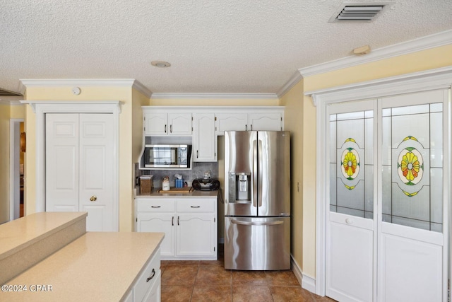 kitchen featuring crown molding, appliances with stainless steel finishes, and white cabinets