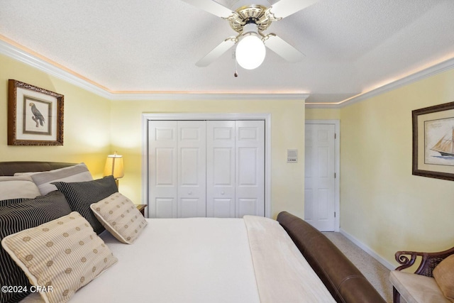 bedroom featuring a closet, ceiling fan, a textured ceiling, light colored carpet, and ornamental molding