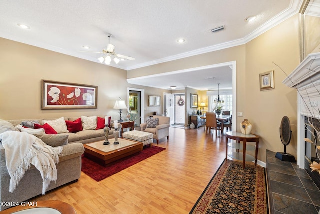 living room with crown molding, wood-type flooring, and a fireplace