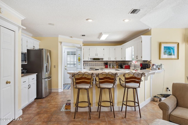 kitchen featuring tasteful backsplash, a healthy amount of sunlight, stainless steel appliances, and light tile flooring