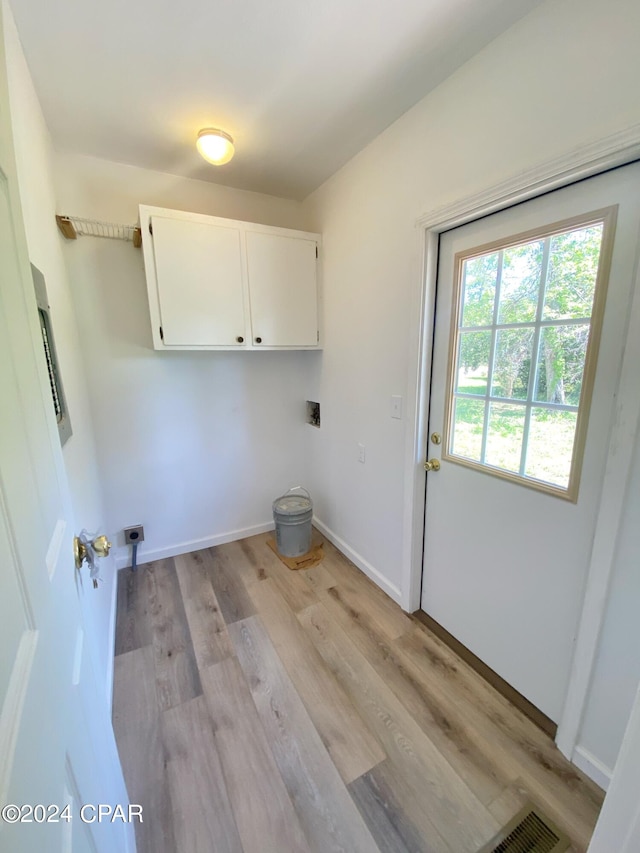 washroom with cabinets, hookup for an electric dryer, and light hardwood / wood-style floors