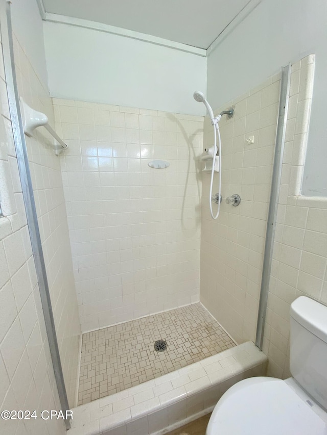 bathroom with tiled shower and toilet