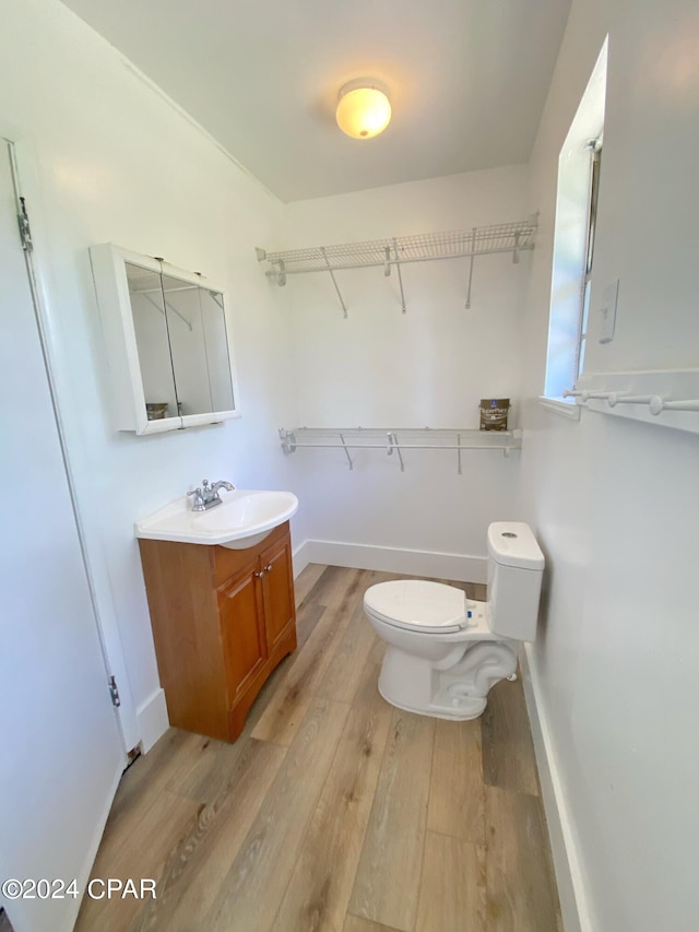 bathroom featuring hardwood / wood-style floors, oversized vanity, and toilet