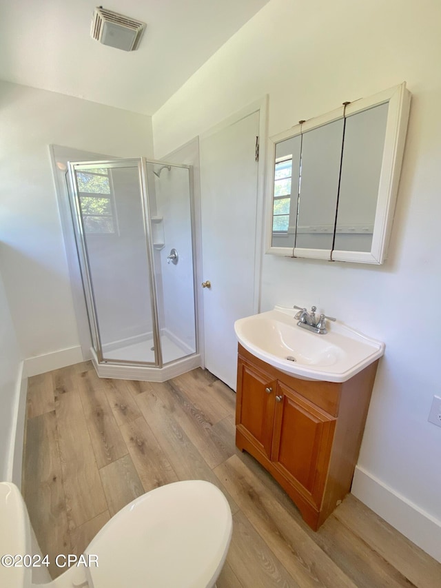 bathroom with hardwood / wood-style floors, vanity, an enclosed shower, and a wealth of natural light