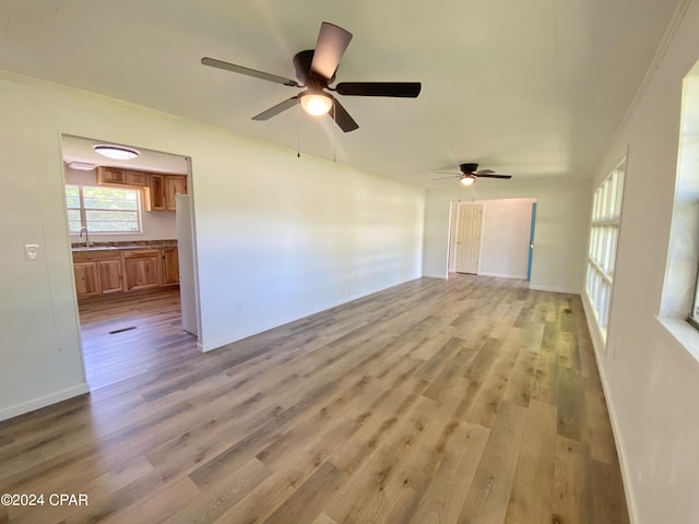 empty room featuring sink, crown molding, ceiling fan, and hardwood / wood-style floors