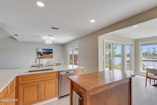 kitchen featuring dishwasher, wooden counters, sink, and light hardwood / wood-style floors