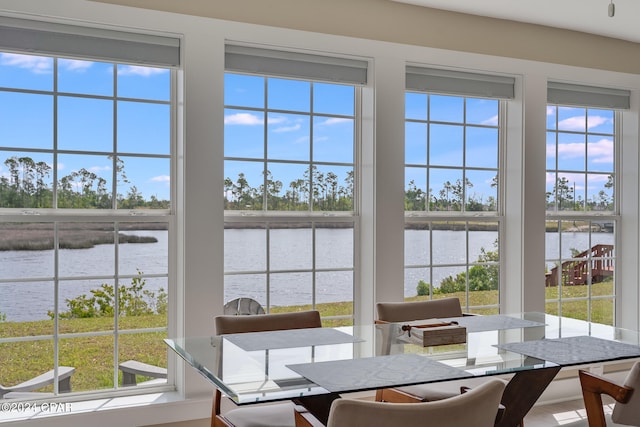 dining room featuring a wealth of natural light and a water view