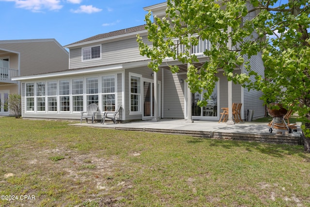 rear view of property featuring a lawn and a patio