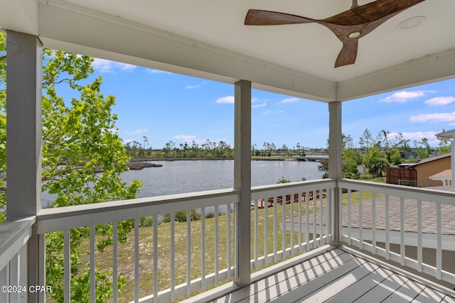 wooden deck with ceiling fan and a water view