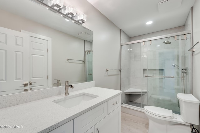 bathroom with walk in shower, toilet, and vanity