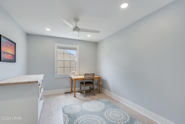 office with light wood-type flooring and ceiling fan