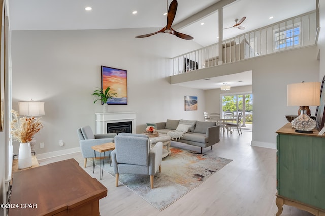 living room featuring high vaulted ceiling, ceiling fan, and light hardwood / wood-style floors