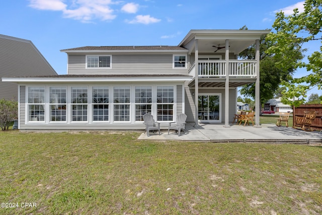 back of house featuring a lawn, ceiling fan, and a patio area