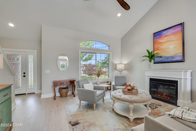 living room featuring high vaulted ceiling, light hardwood / wood-style flooring, and ceiling fan