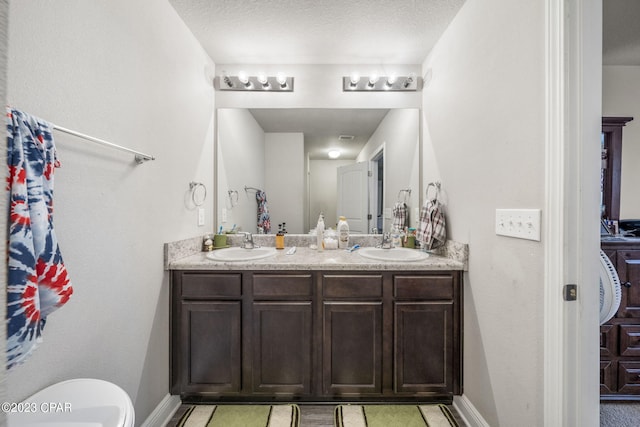 bathroom featuring tile flooring, dual vanity, and a textured ceiling