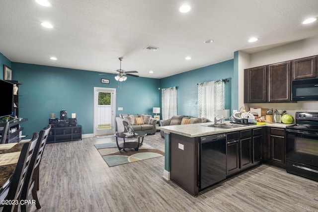 kitchen with ceiling fan, black appliances, sink, and light wood-type flooring