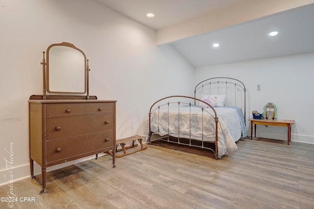 bedroom featuring lofted ceiling with beams and light hardwood / wood-style floors