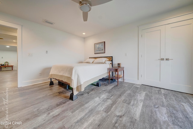 bedroom with hardwood / wood-style floors, a closet, and ceiling fan