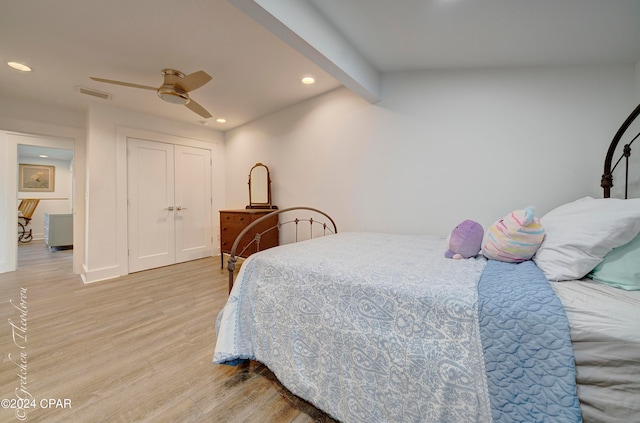 bedroom featuring a closet, ceiling fan, vaulted ceiling with beams, and light wood-type flooring