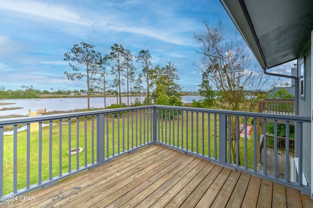 wooden deck featuring a lawn and a water view