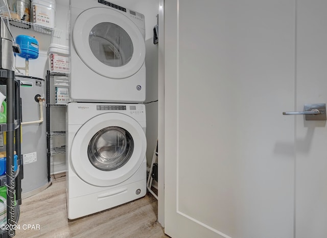 clothes washing area with stacked washer / dryer and light wood-type flooring