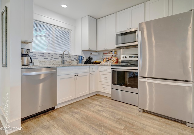 kitchen featuring white cabinets, light hardwood / wood-style floors, and stainless steel appliances