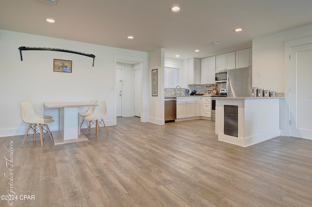 kitchen featuring appliances with stainless steel finishes, light wood-type flooring, and white cabinets