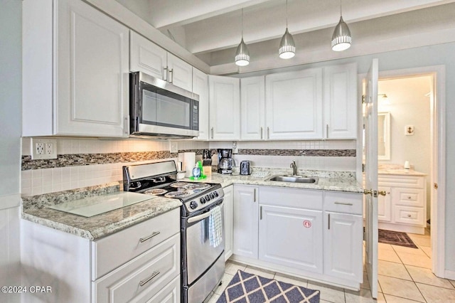 kitchen featuring light tile floors, range with gas cooktop, white cabinets, and sink