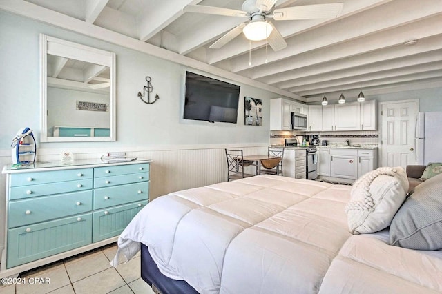 tiled bedroom featuring white refrigerator, beam ceiling, ceiling fan, and sink