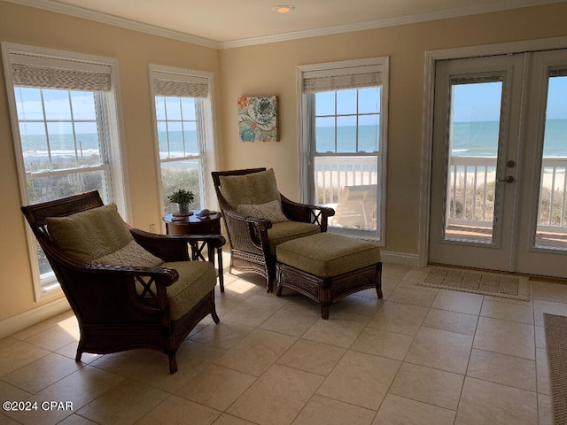 sitting room with crown molding, light tile floors, and a wealth of natural light