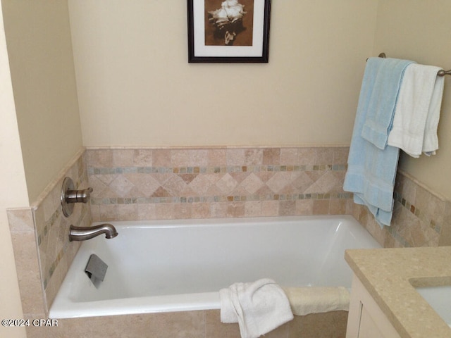 bathroom featuring vanity and a relaxing tiled bath