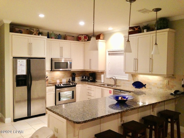 kitchen featuring decorative light fixtures, sink, appliances with stainless steel finishes, and backsplash