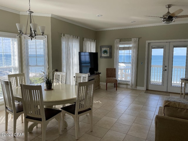 dining area with french doors, a water view, ceiling fan with notable chandelier, light tile floors, and ornamental molding