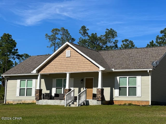 craftsman house with a front yard and covered porch