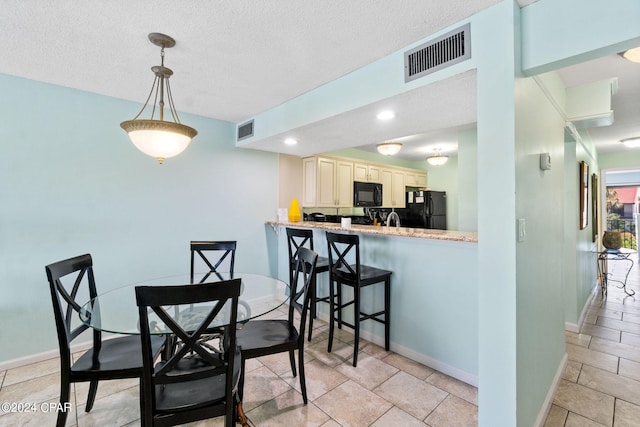 dining area with light tile flooring and a textured ceiling