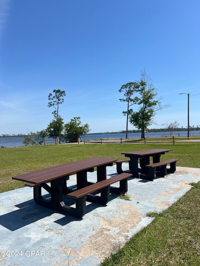 view of home's community with a water view and a yard