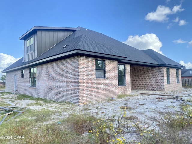 610 Shady Oaks Ln, Lynn Haven, FL 32444 - view of side of home with brick siding, board and batten siding, and roof with shingles