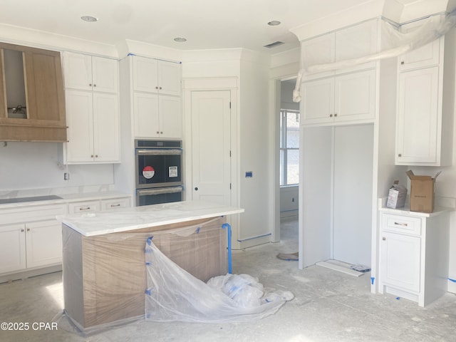 kitchen with visible vents, white cabinetry, light countertops, and stainless steel double oven